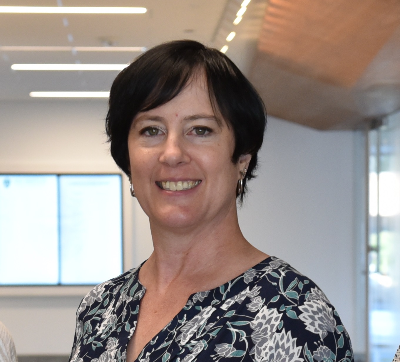 barbara has short black hair and wears a dark printed top