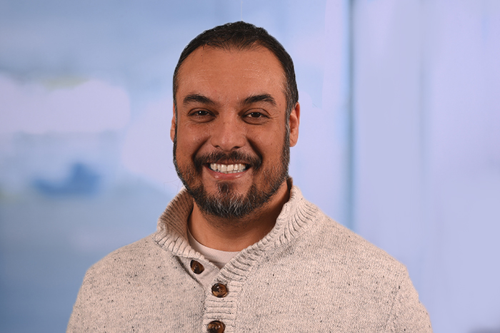 jorge has a cream colored sweater on with brown buttons