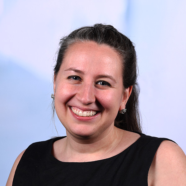 megan has her hair in a braid and wears a sleeveless black shirt