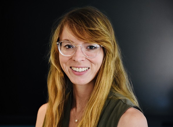 emma wears clear rimmed glasses and has strawberry blonde hair