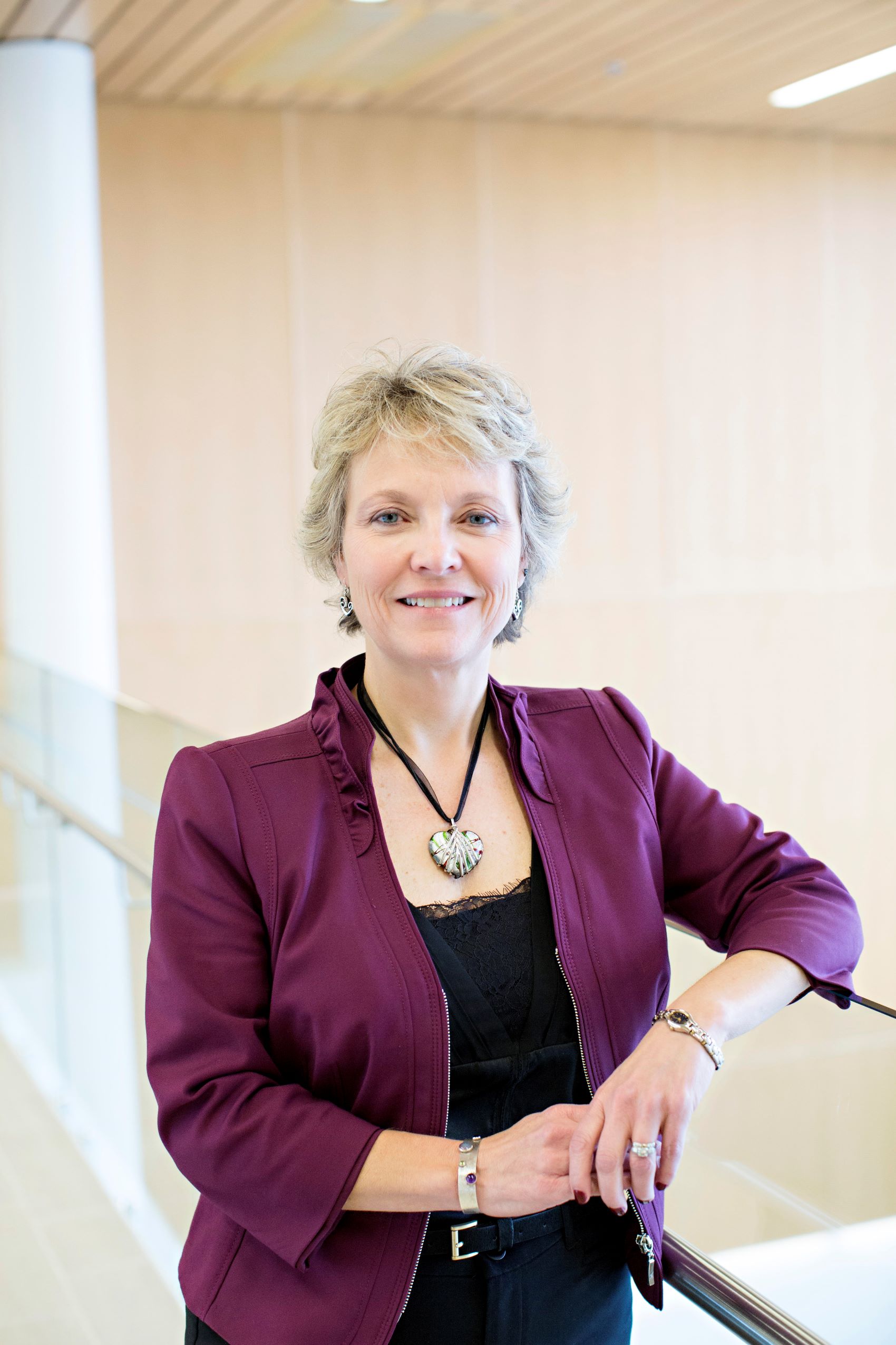 Lisa Donegan Shoaf has short light blond hair and is wearing a black shirt and dark purple jacket