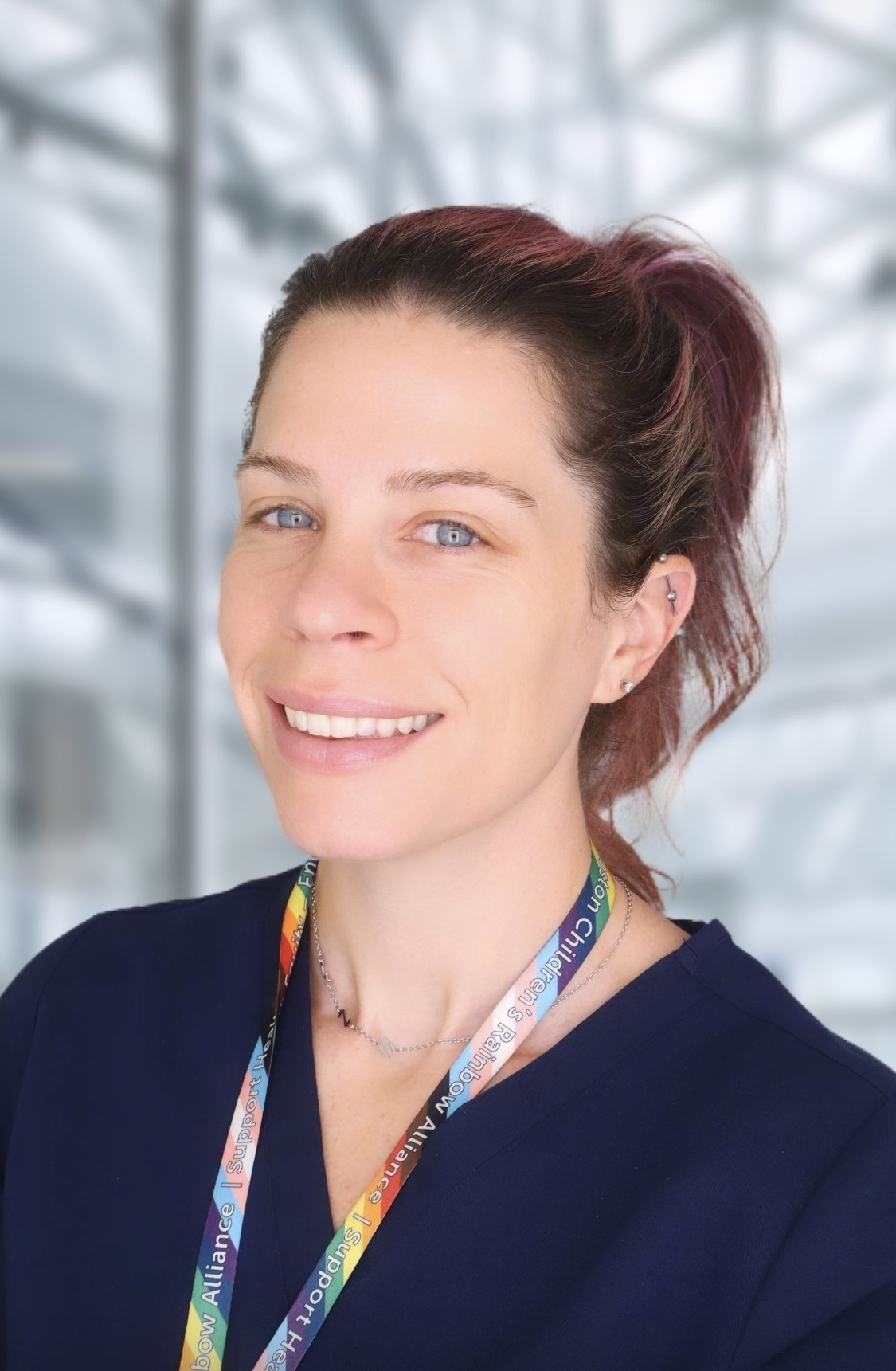 Brenna has a high ponytail and a rainbow lanyard around her neck