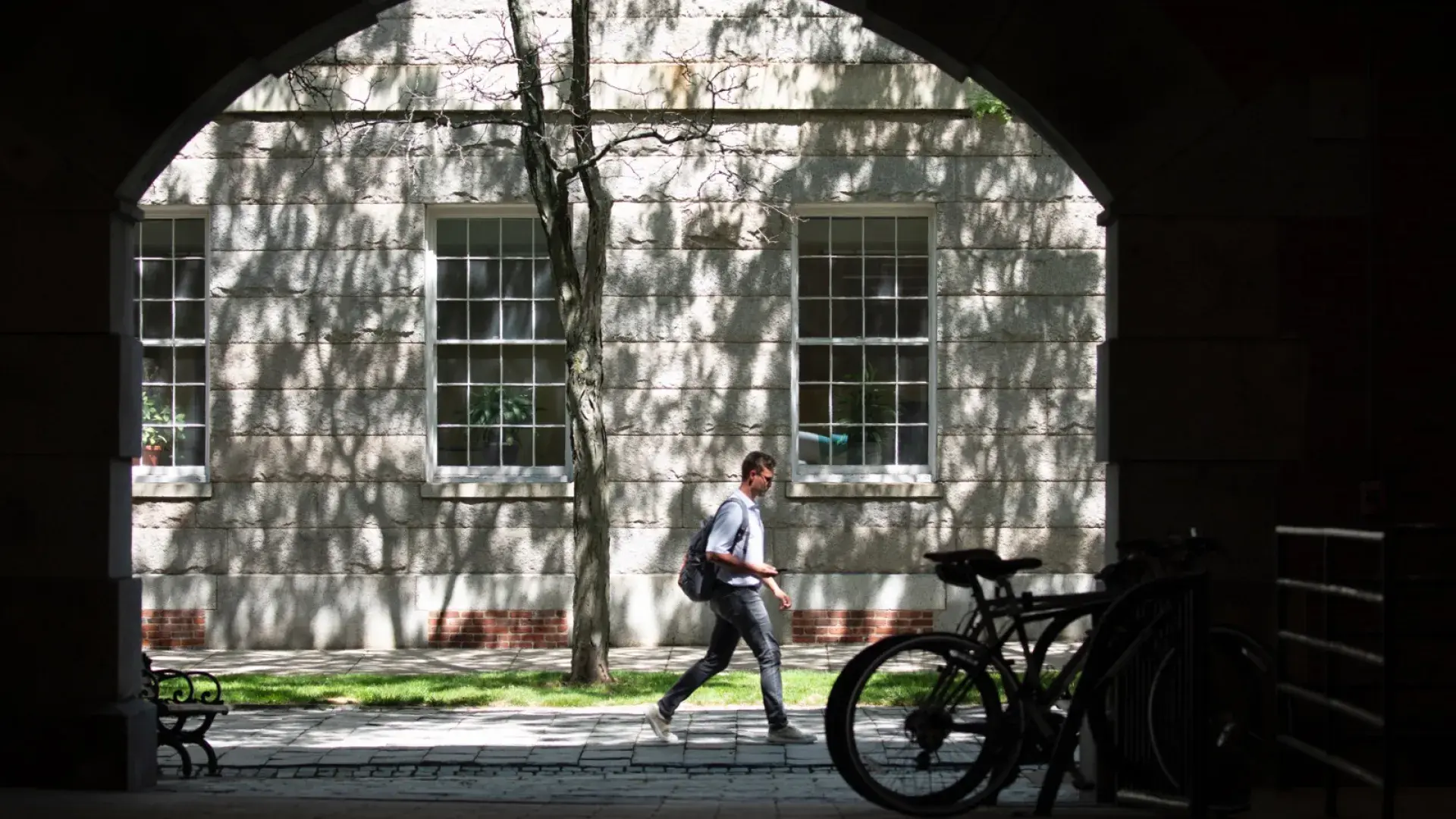 Young man walking through Boston alleyway.