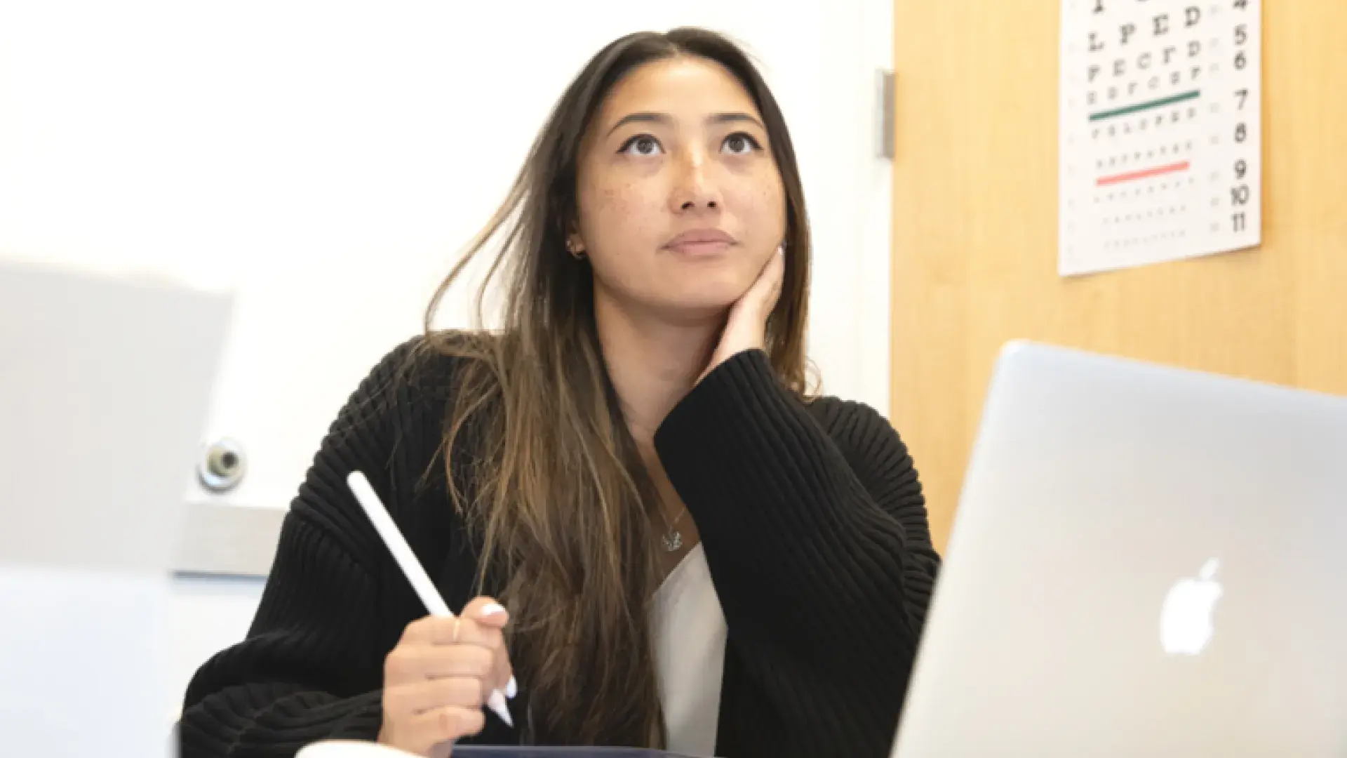Woman studying at a desk with a laptop and tablet