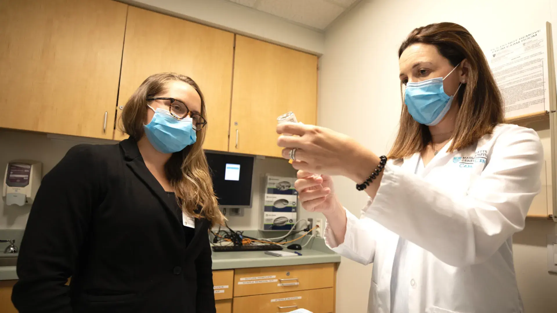 Physician and a woman with masks on in a doctors office