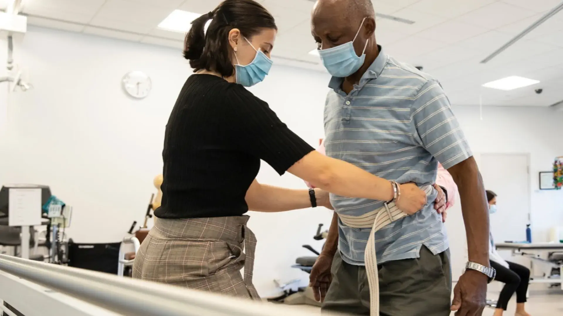 Woman helping a man during physical therapy session