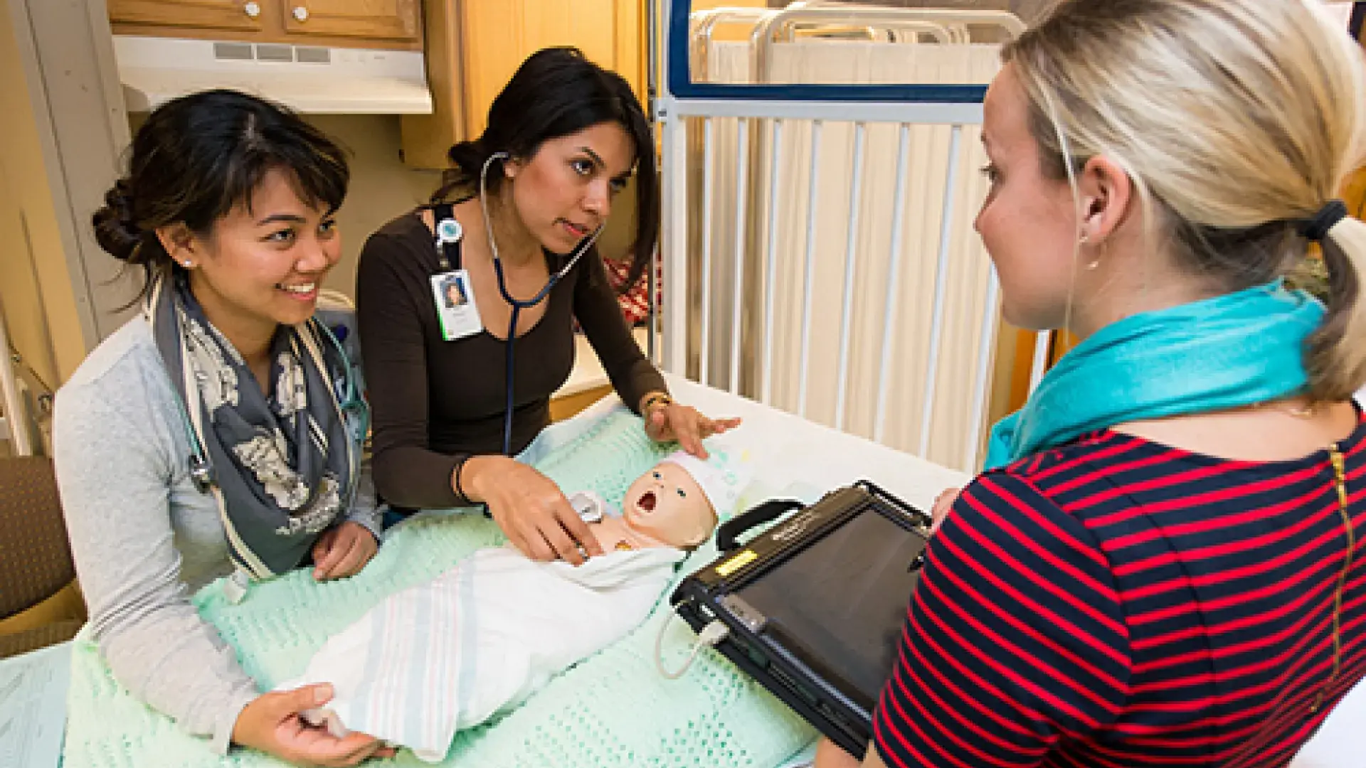 Three woman training on a mannequin doll
