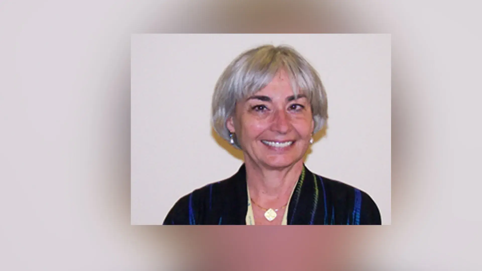 photo of BA she wears a dark blue velvet jacket and has short grey hair