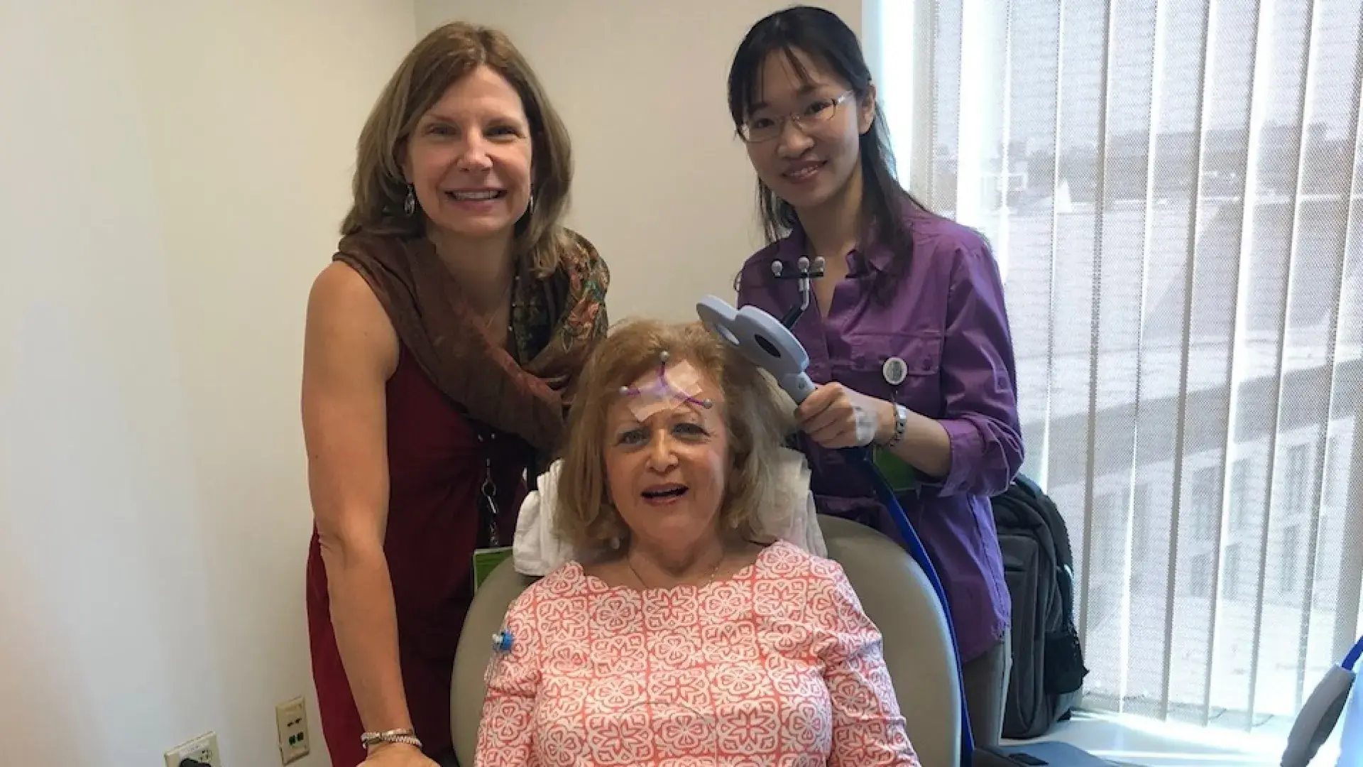 Two BRL Team Members Working together holding a device that looks like a T to a patient's head