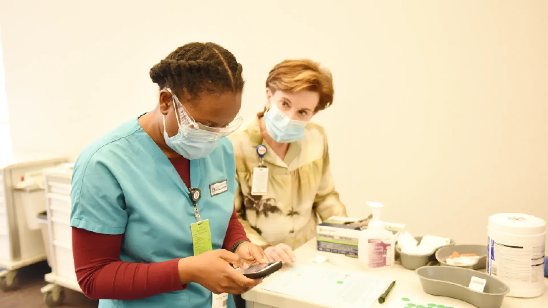 Jeanette Ives Erickson works with an IHP BSN student an MGB vaccination clinic in April 2021. Under her leadership, 100,000 patients received vaccinations.