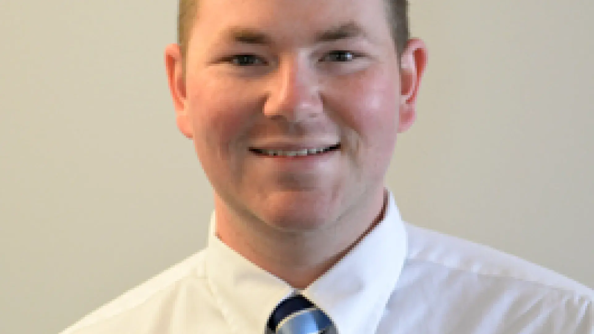 Jack Fitzgerald center of image with beige background.