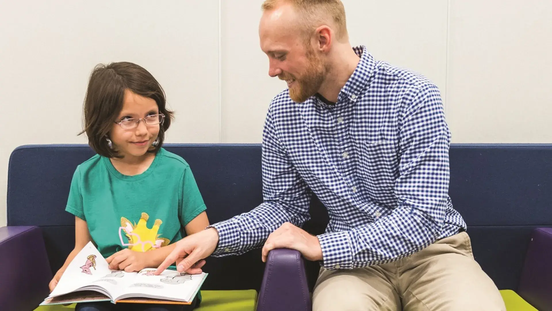 A literacy coach in the MGH IHP Literacy and Language Certificate Program helps a young student with reading comprehension. The program focuses on evidence-based literacy instruction and advanced literacy strategies, preparing educators for reading specialist certification and literacy leadership training.