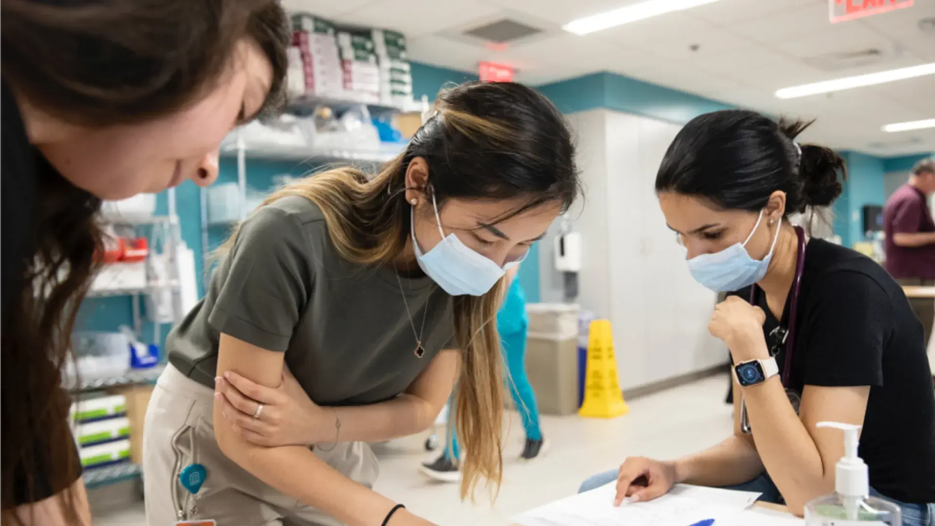 Three woman around a table studying