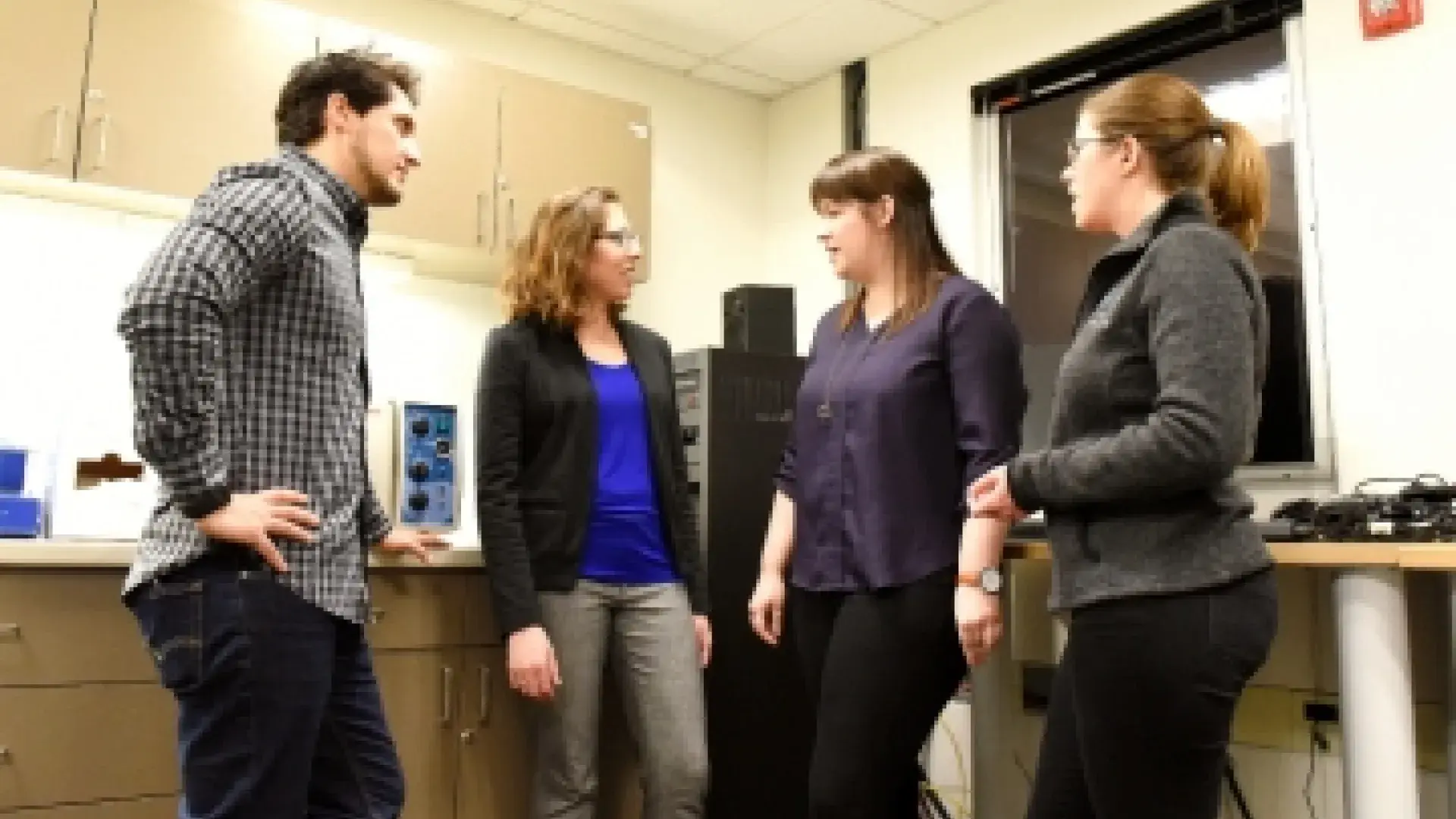 Katie Stipancic, third from left, talks with fellow PhD students Paulo Teixeira, Megan Schliep, and Katherine Marks in the Center for Health and Rehabilitation Research.