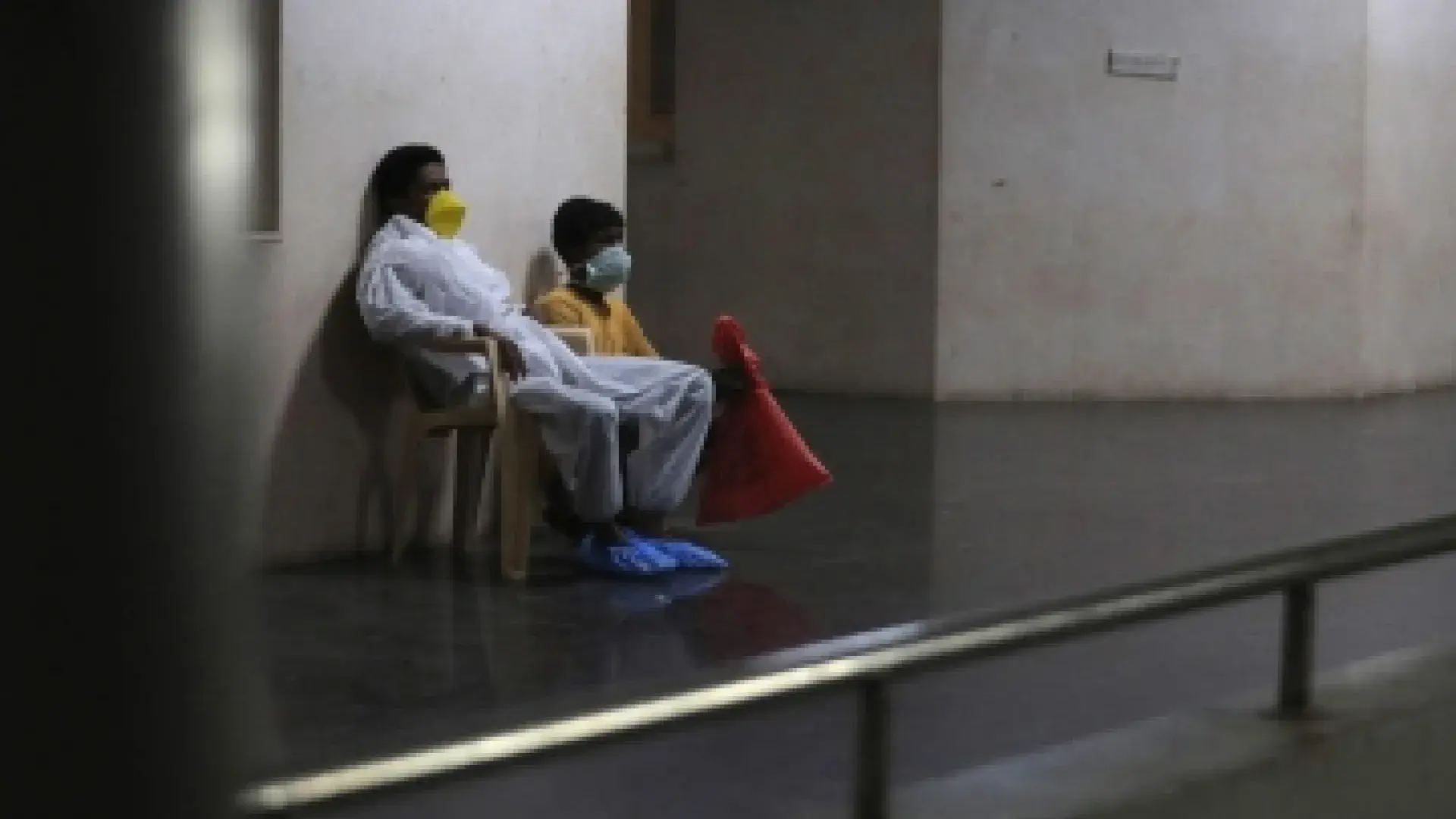 2 people with masks on sitting next to each other