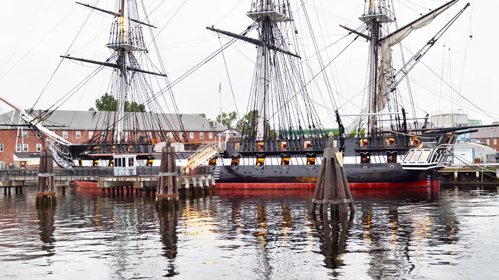 three masted schooner is reflected in the ocean water