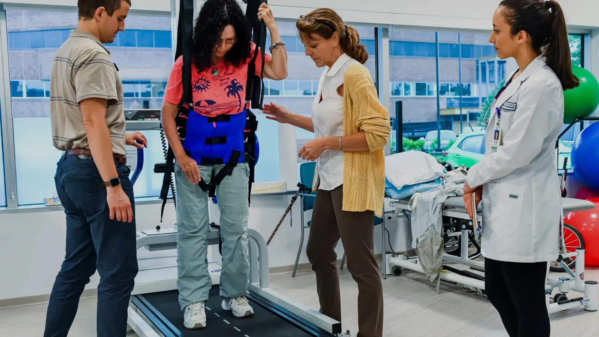 A patient undergoing rehabilitation therapy on a treadmill with assistance, demonstrating the hands-on approach in the DPT program.