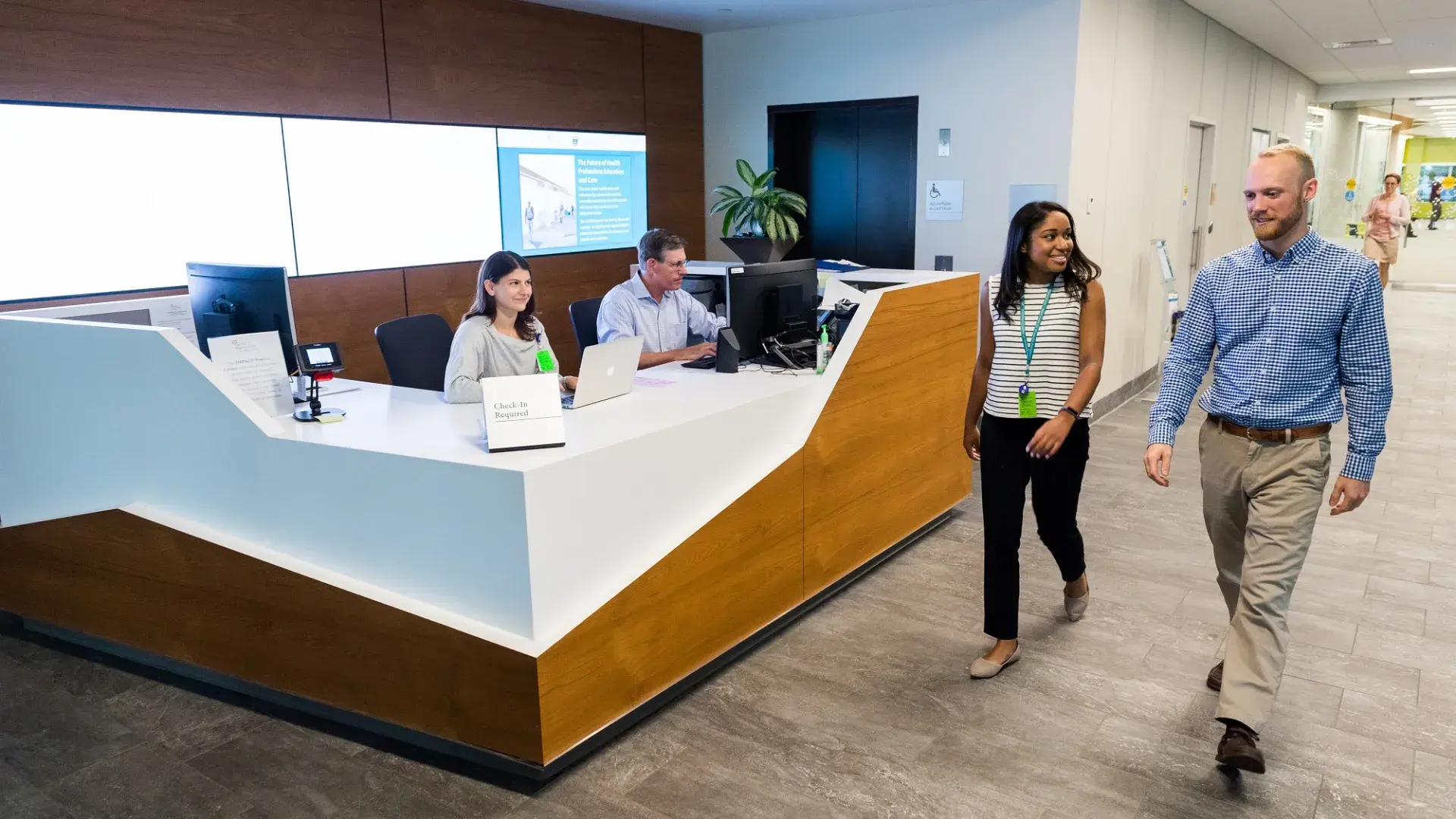 People walking on campus past welcome desk