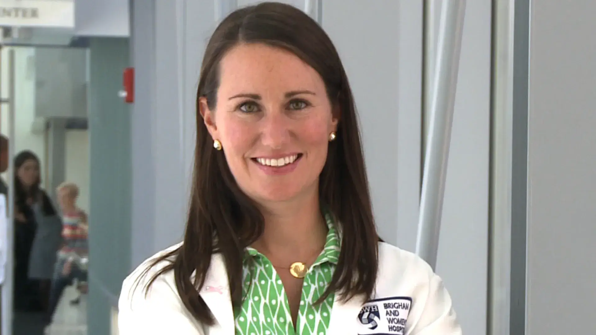 Bridget stands with her arms folded with a smile