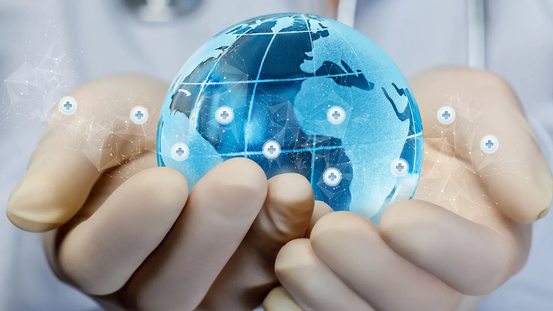 a blue glass globe is held in two white latex gloved hands