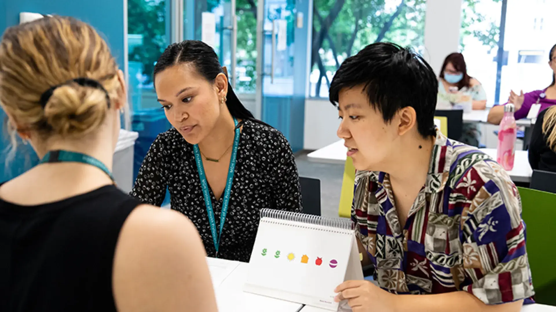 Three individuals engaging in discussion around evidence-based literacy instruction techniques.
