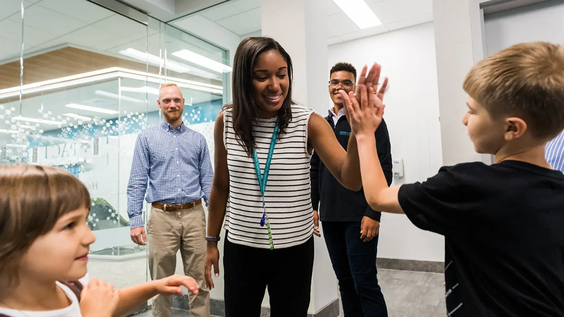 woman gives high five to child in hallway