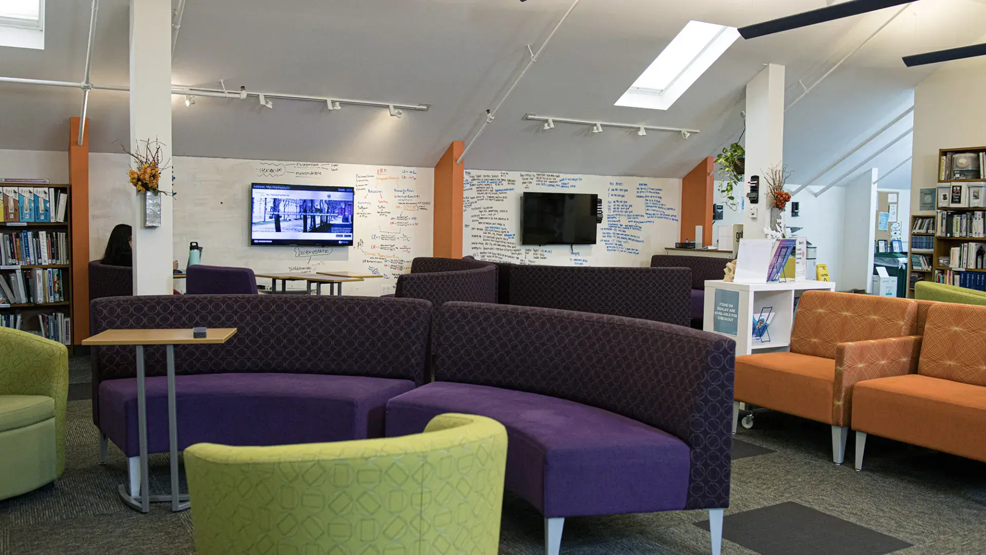 colorful couches - orange, purple and green sit in a room with writing on the walls