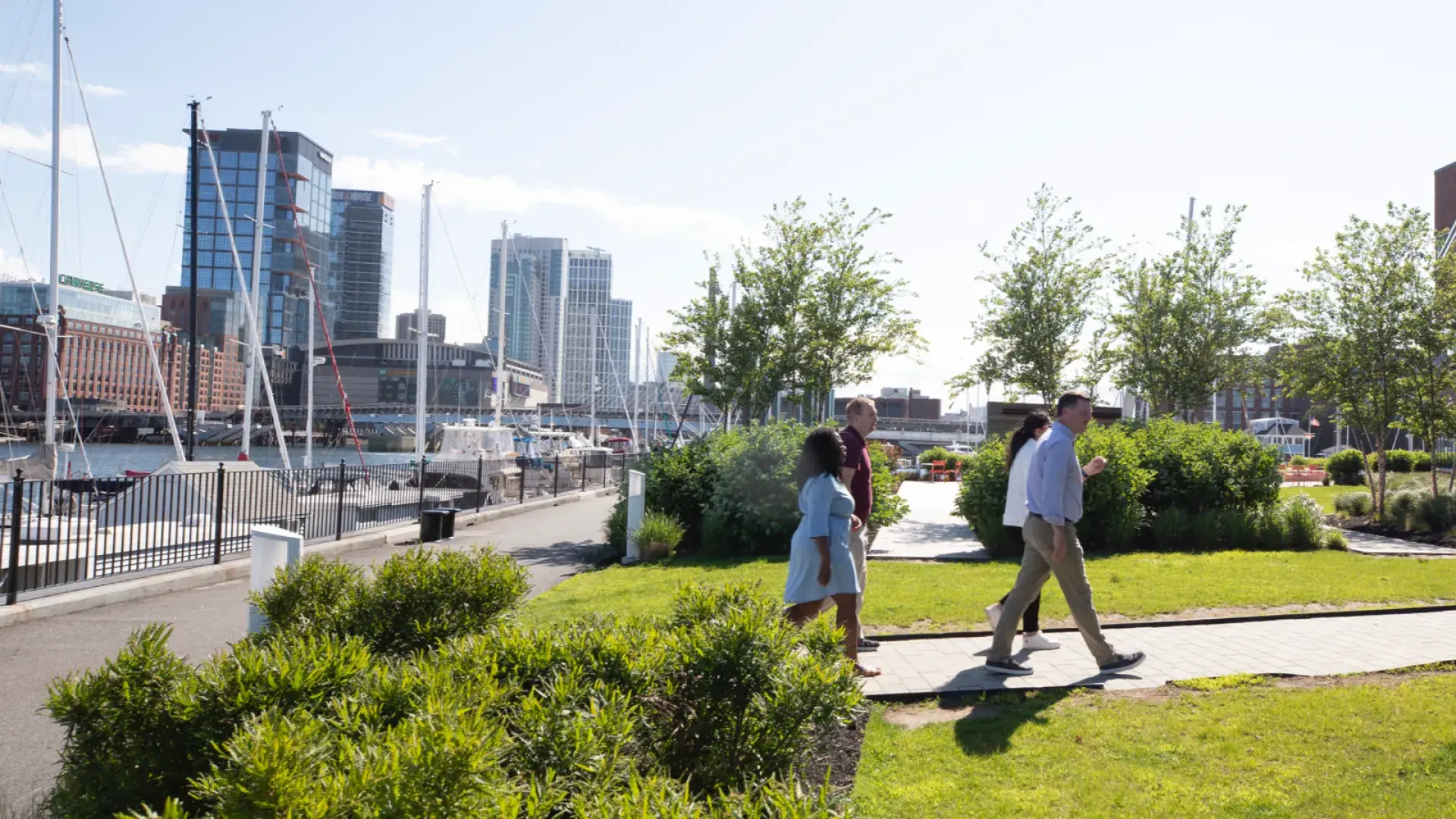 People walking in a park with the waterfront in the backround