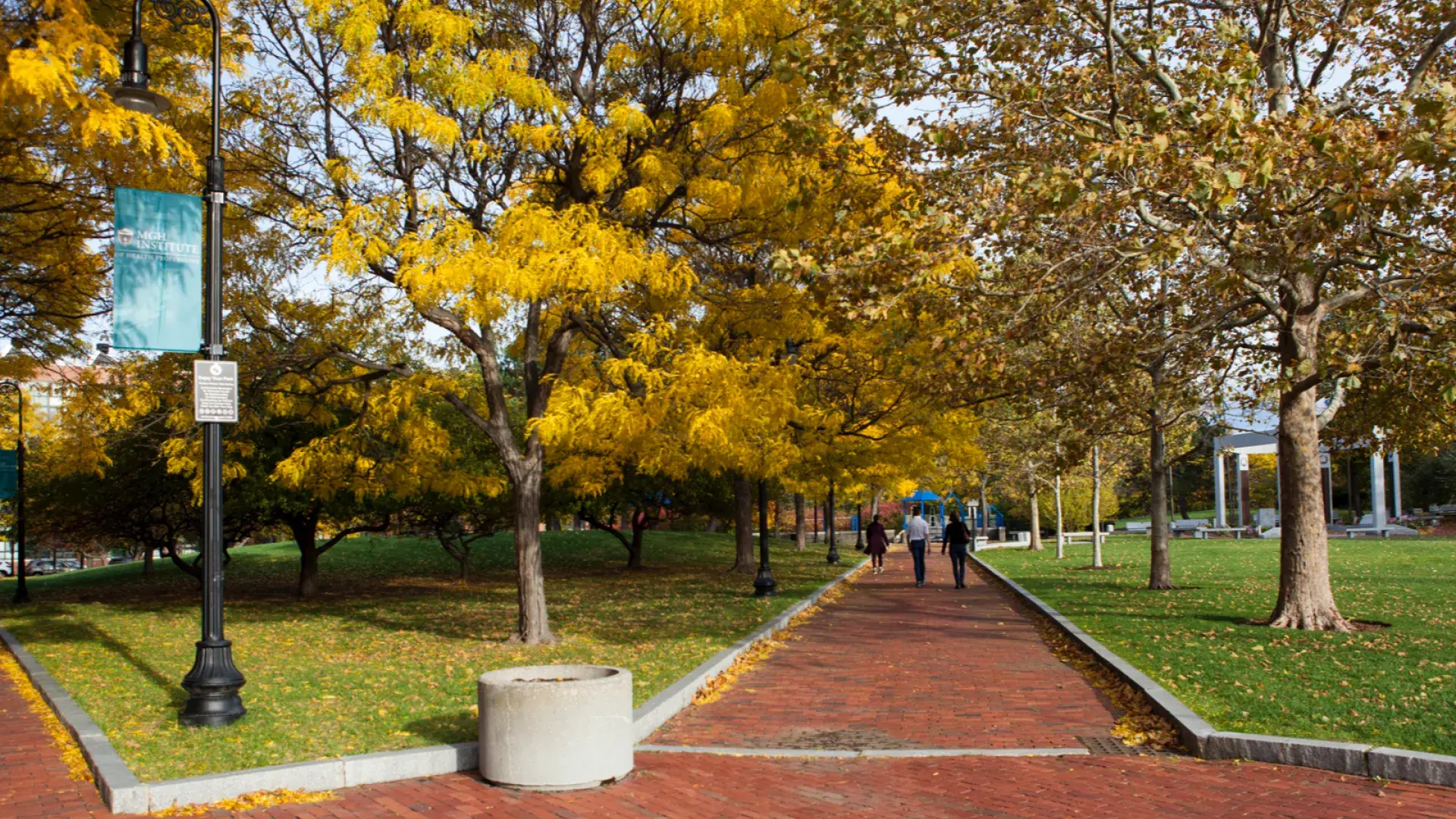Brick walkway through a park during the fall
