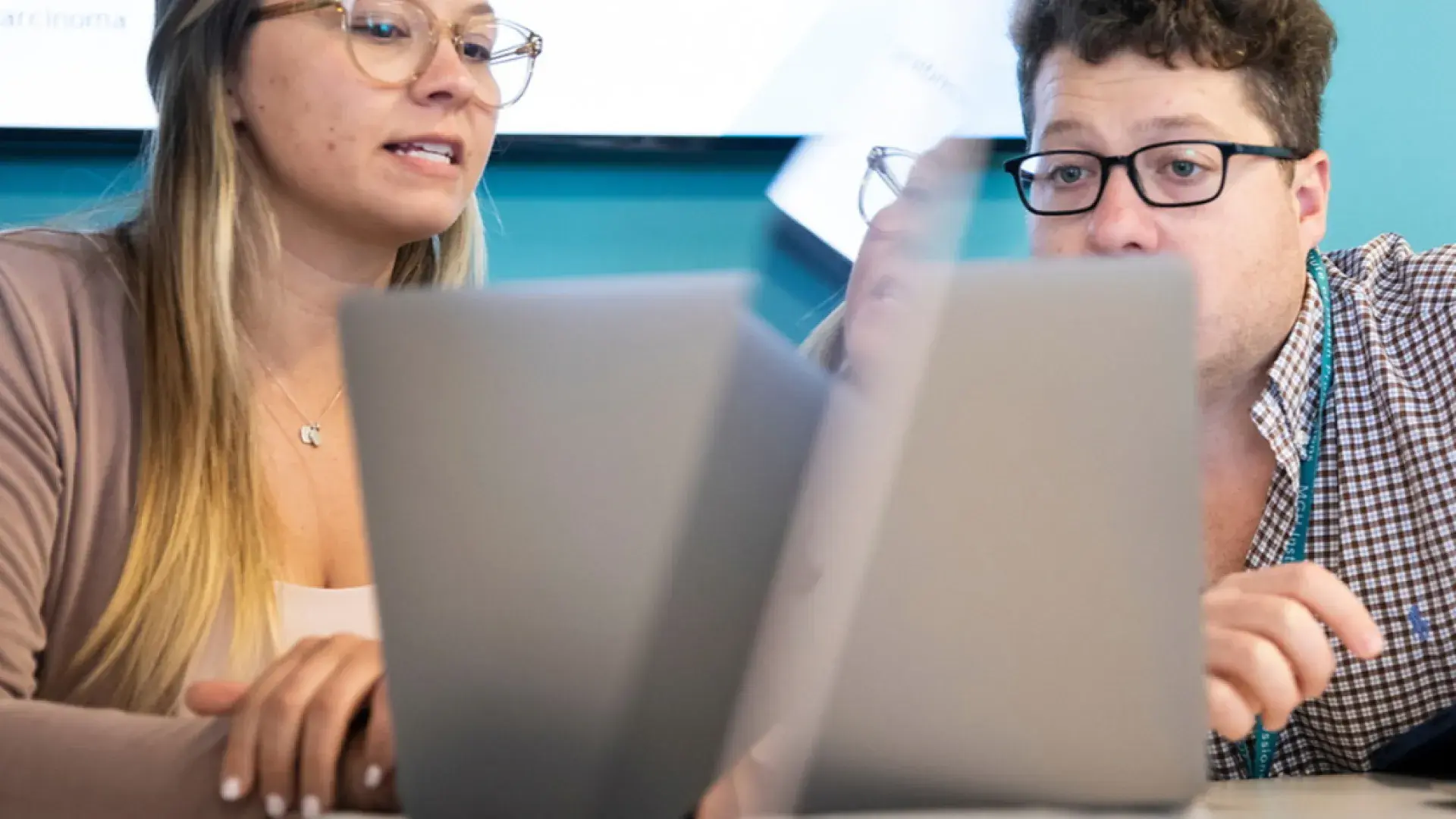 Two people lookin at a laptop together