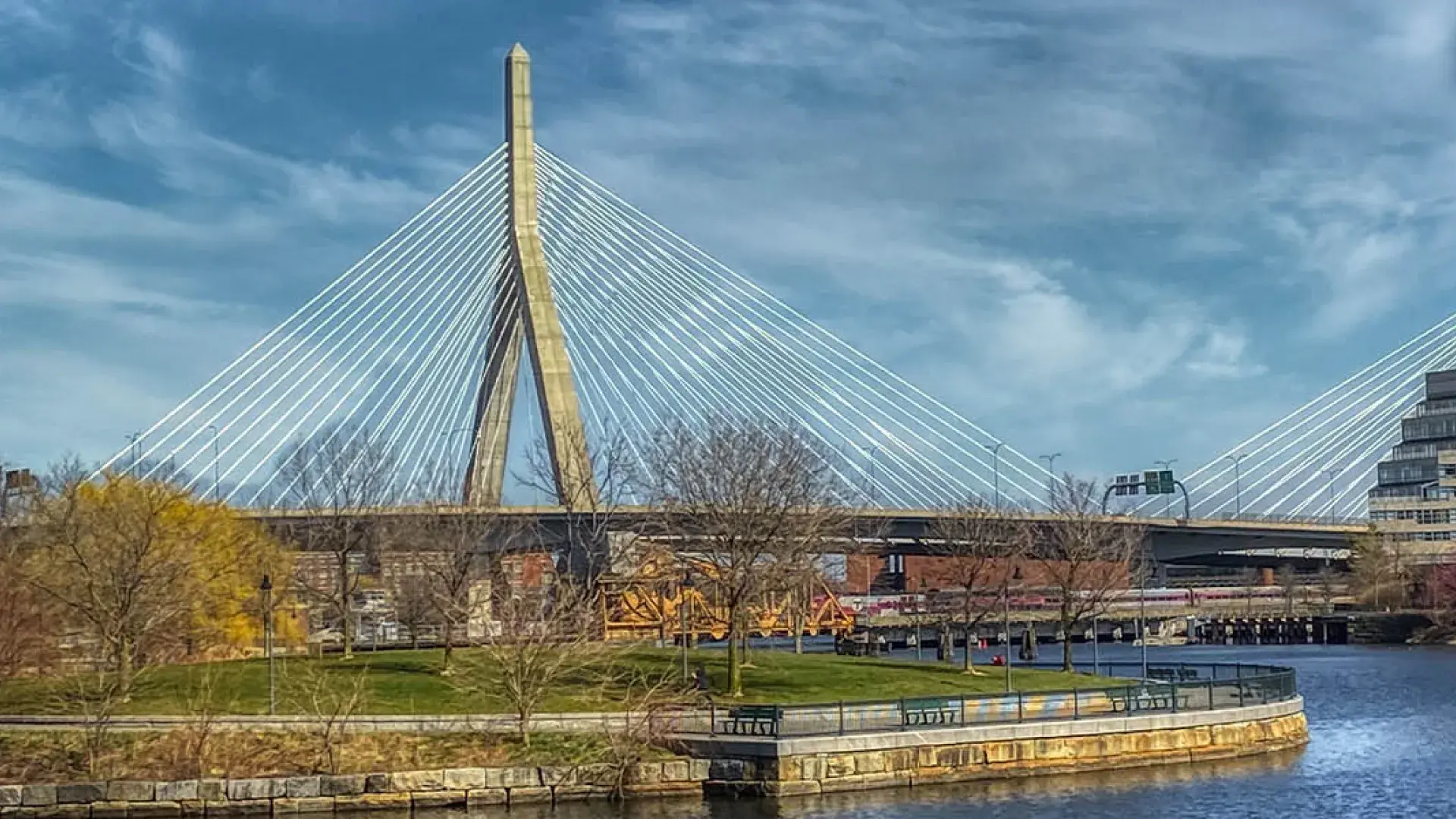 suspension bridge over a river with a blue sky