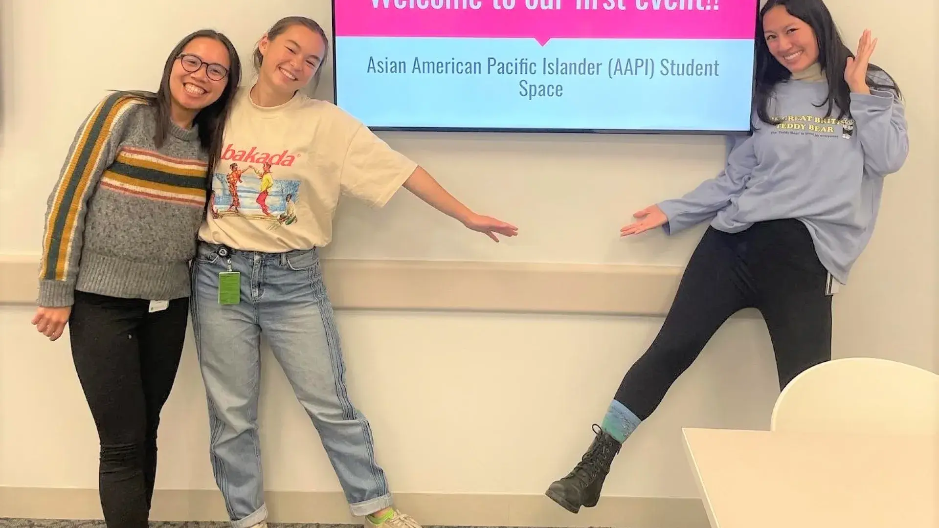 three fellows stand next to a screen that reads welcome to our first event