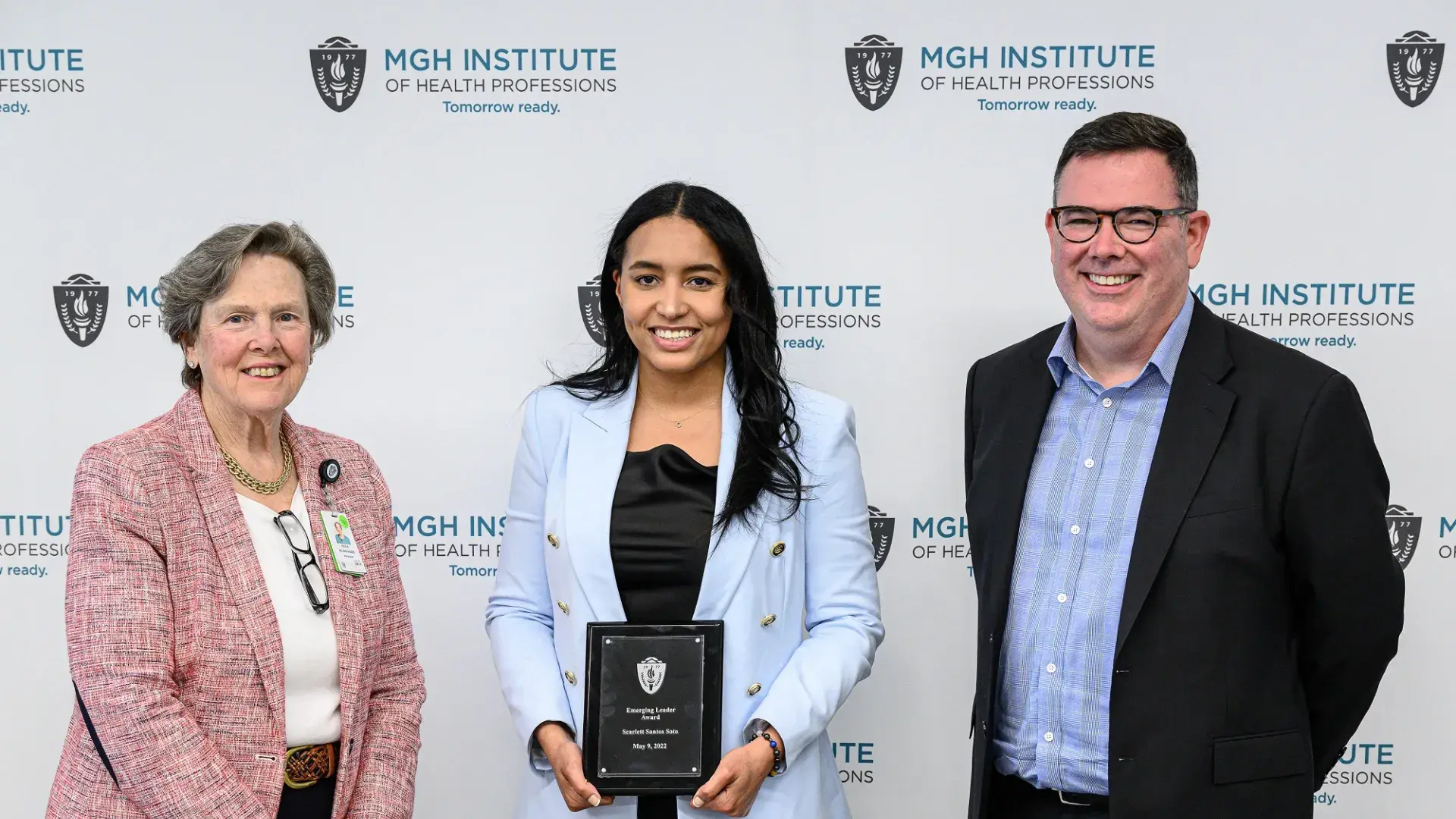 woman in middle with baby blue blazer holds plaque 