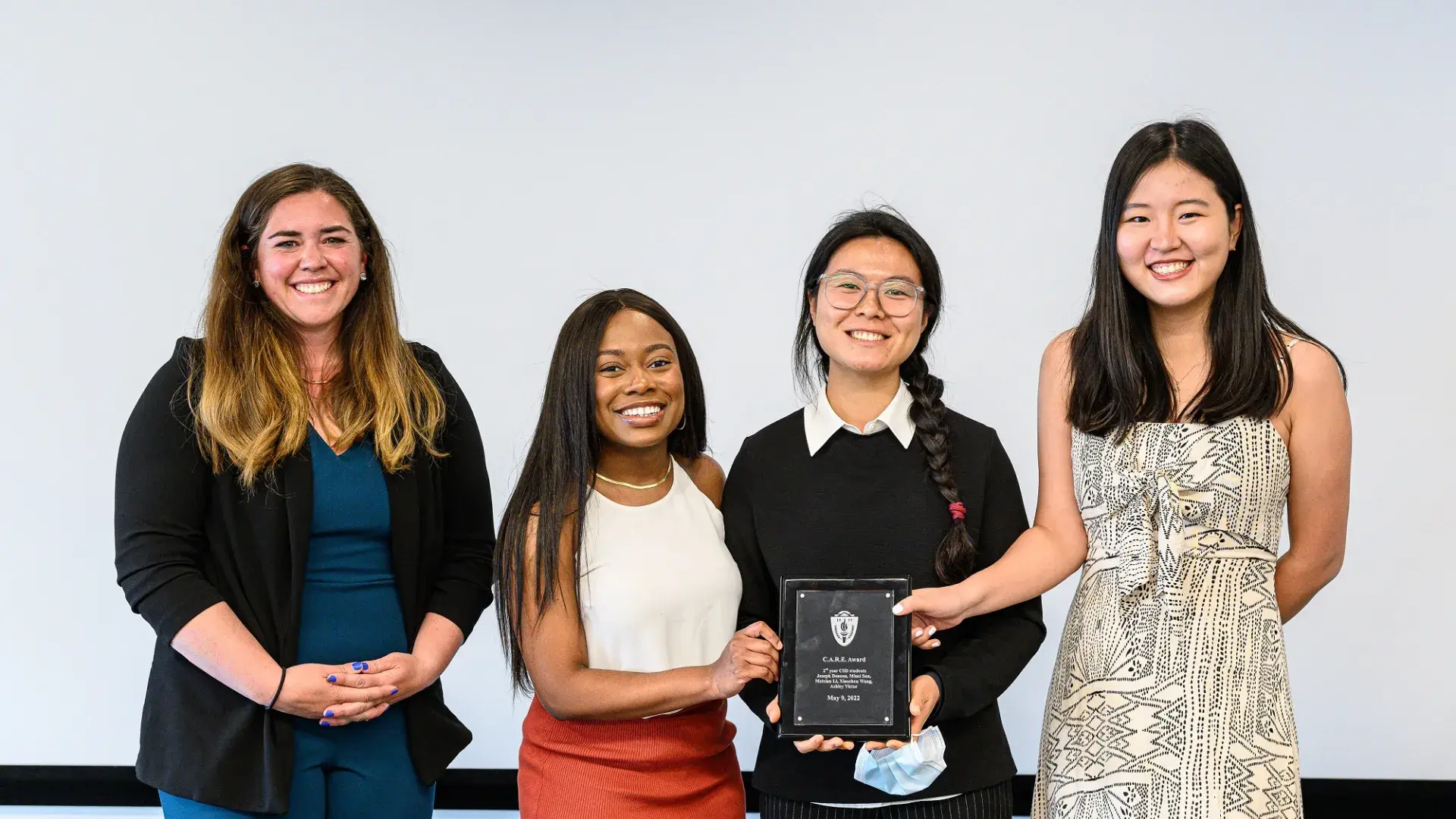 gorup of students holds a plaque