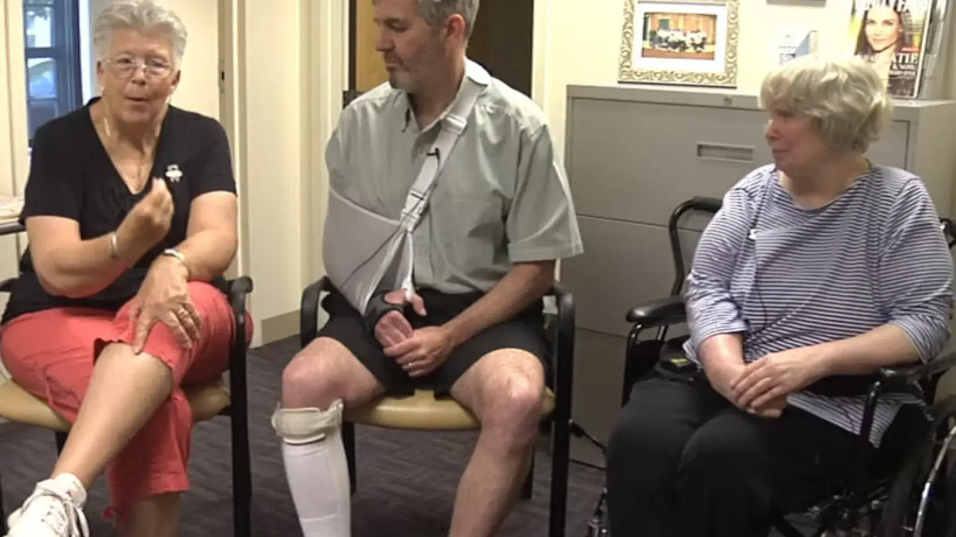 three older people sit in chairs, a man and two women