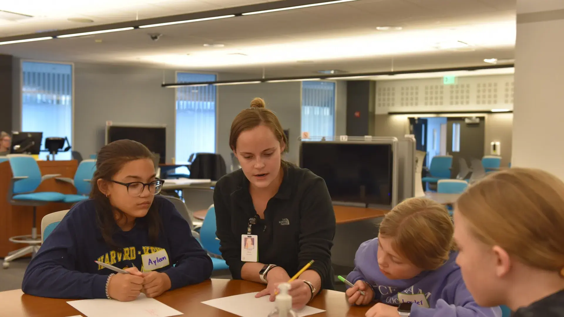 Fifth-grader, Ayleen (left) watches nursing student Lauren O'Neil (center). They're joined by two other Harvard-Kent students