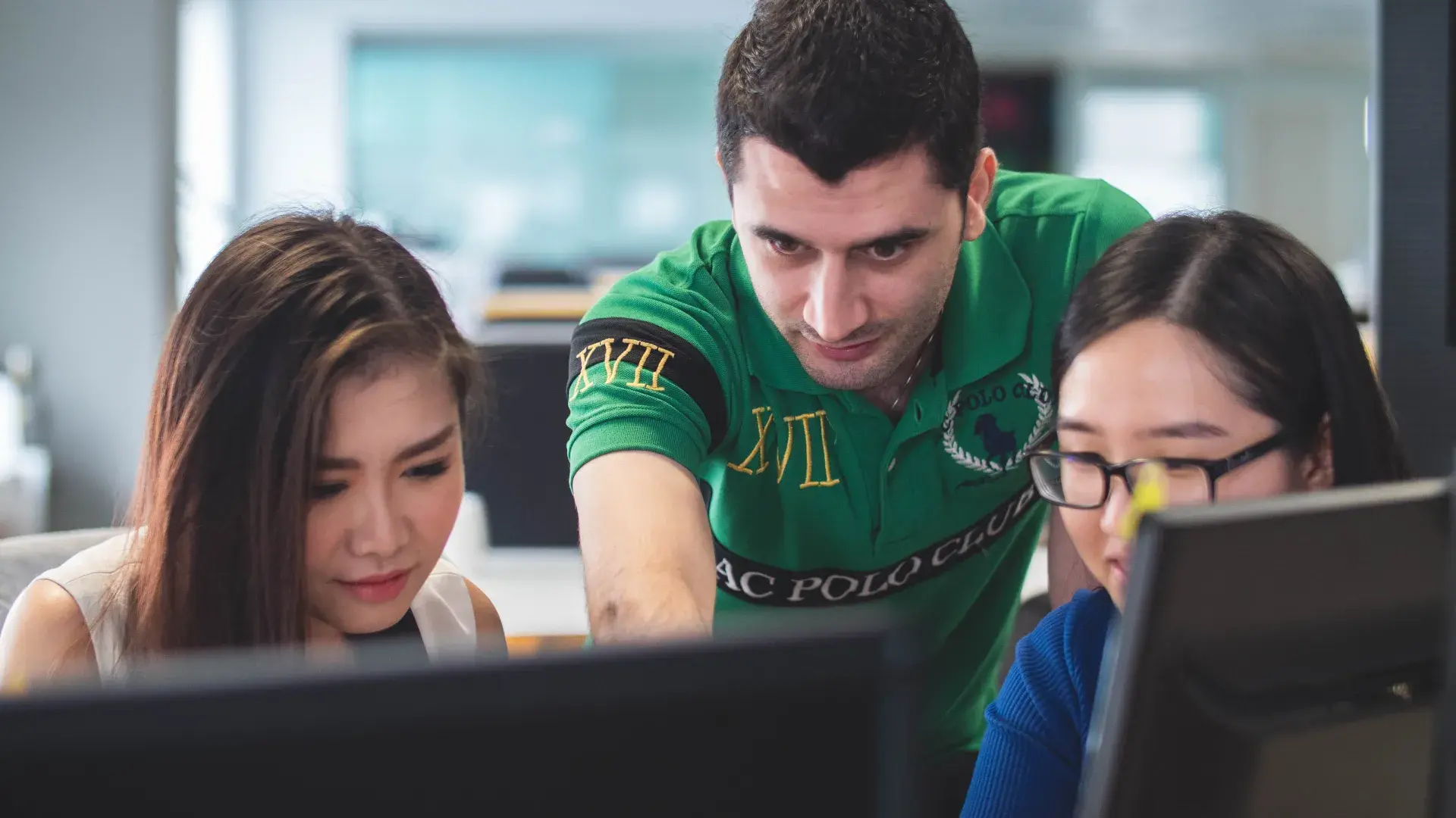 man and two women on laptops