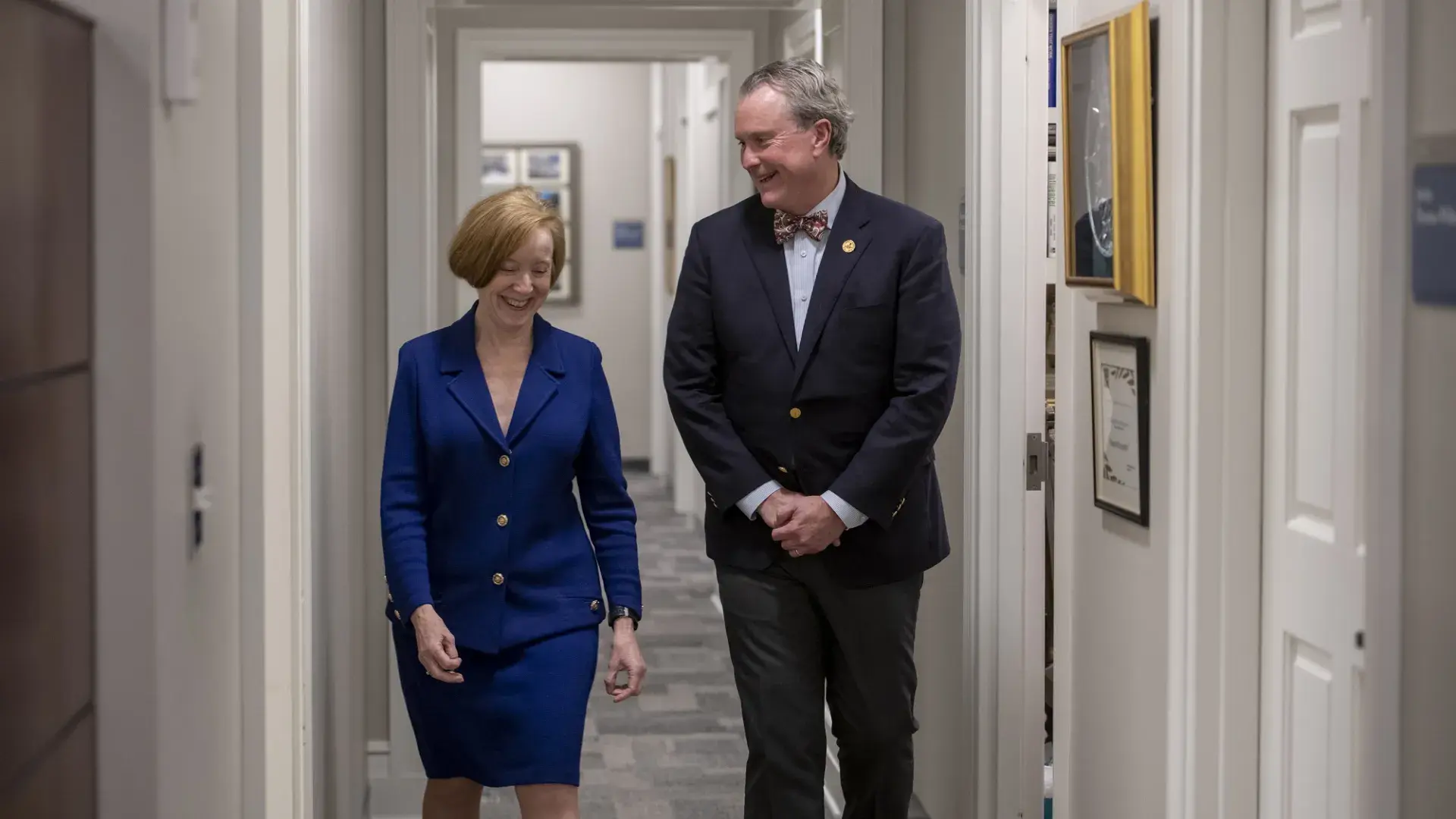 debbie and ken walk down a hallway