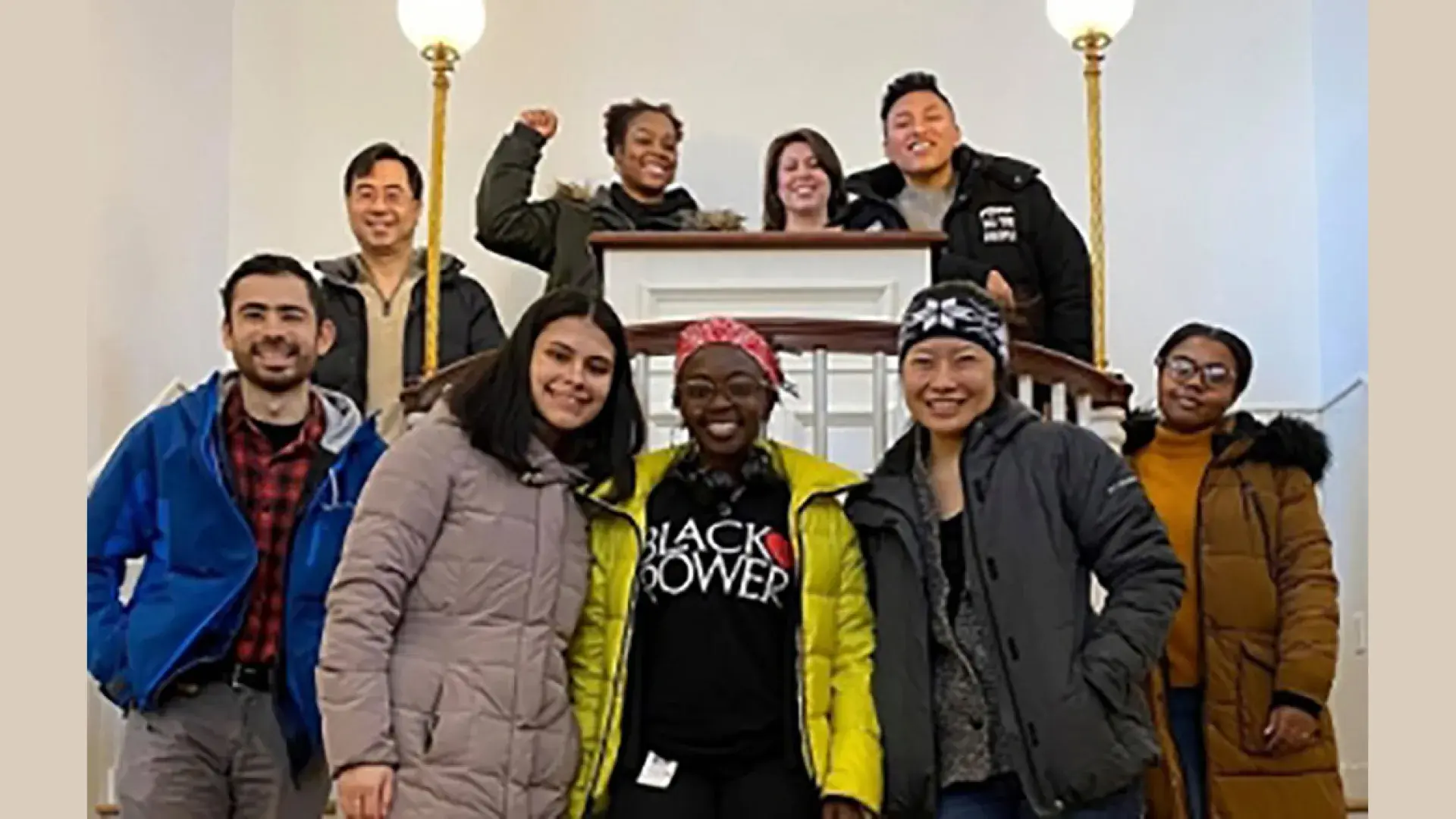 Photo of multiple people standing around a podium. 