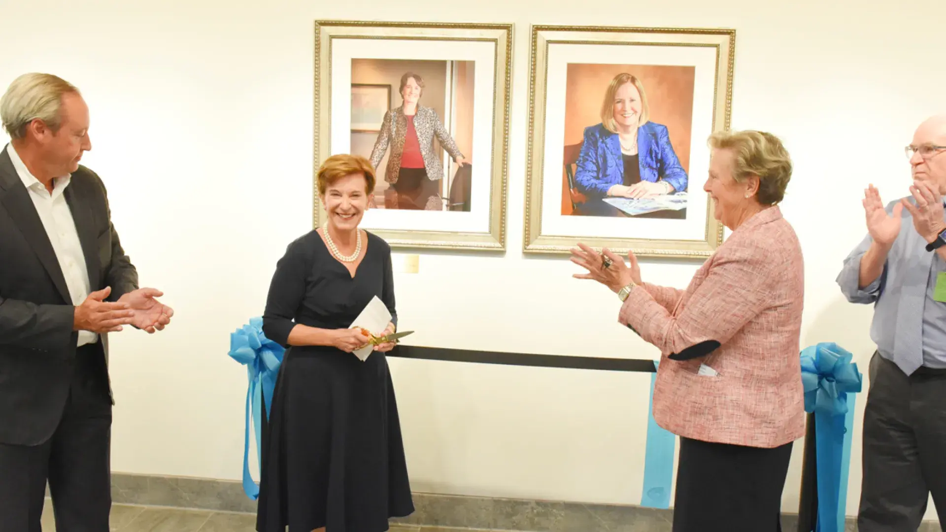 Board Chair Jeanette Ives Erickson (second from left) smiles after unveiling portraits in the new Presidents’ Hall. Also celebrating are (l-r) Trustee Jim Canfield, President Paula Milone-Nuzzo, and Chief Operating Officer Denis Stratford.