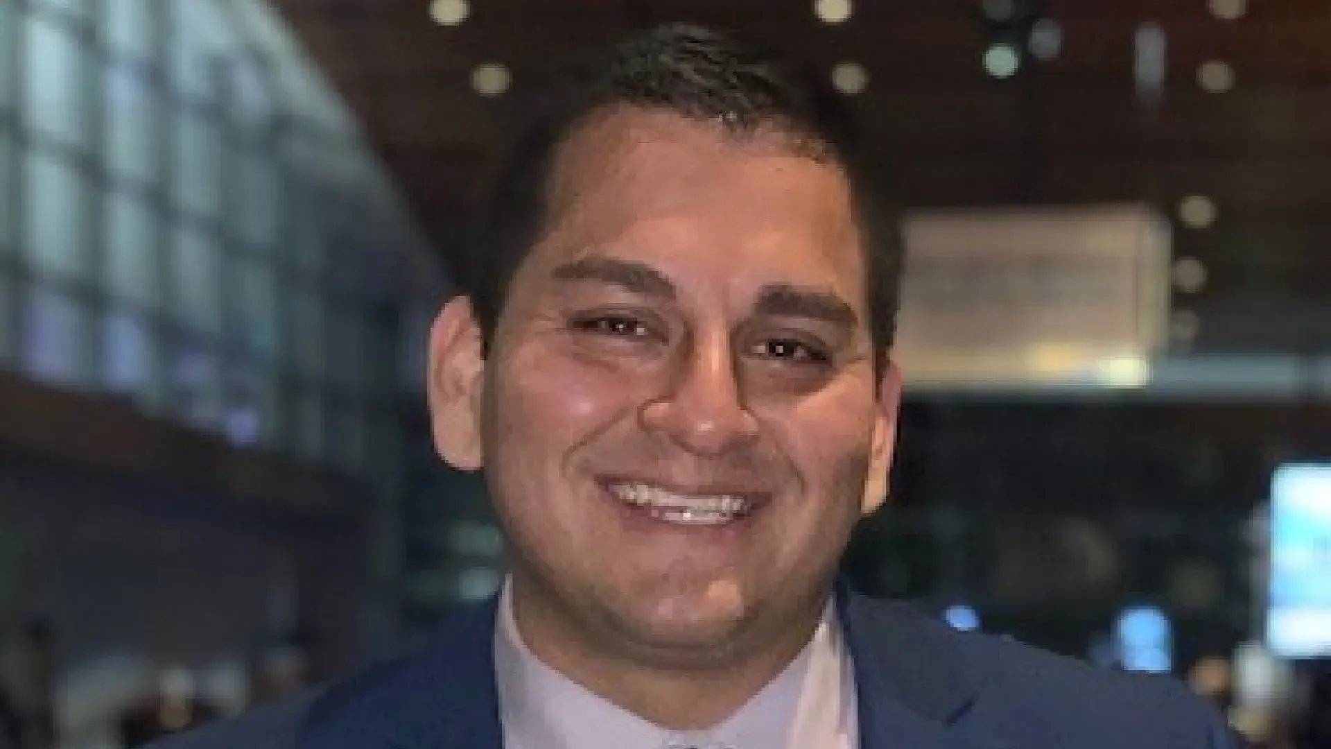 man in blue business suit smiles for the camera