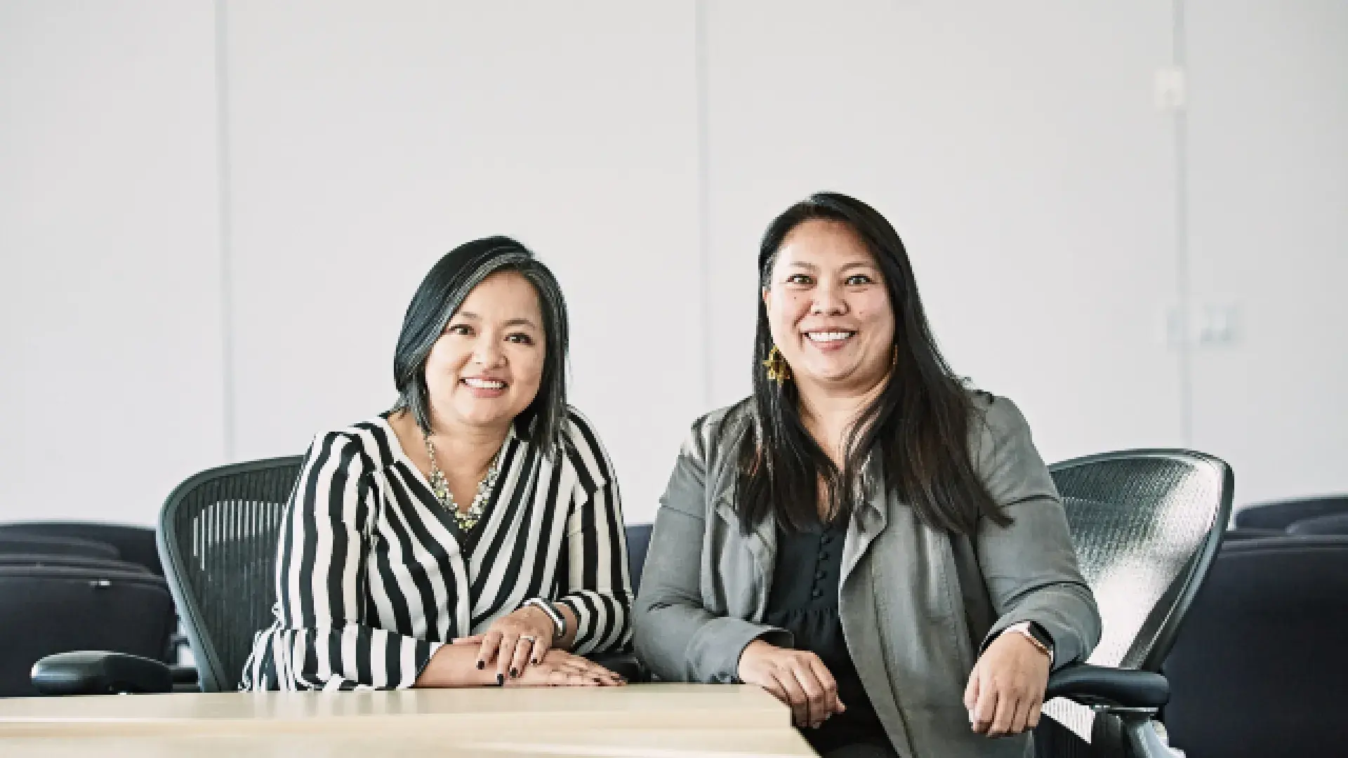 two Asian women sit at a table