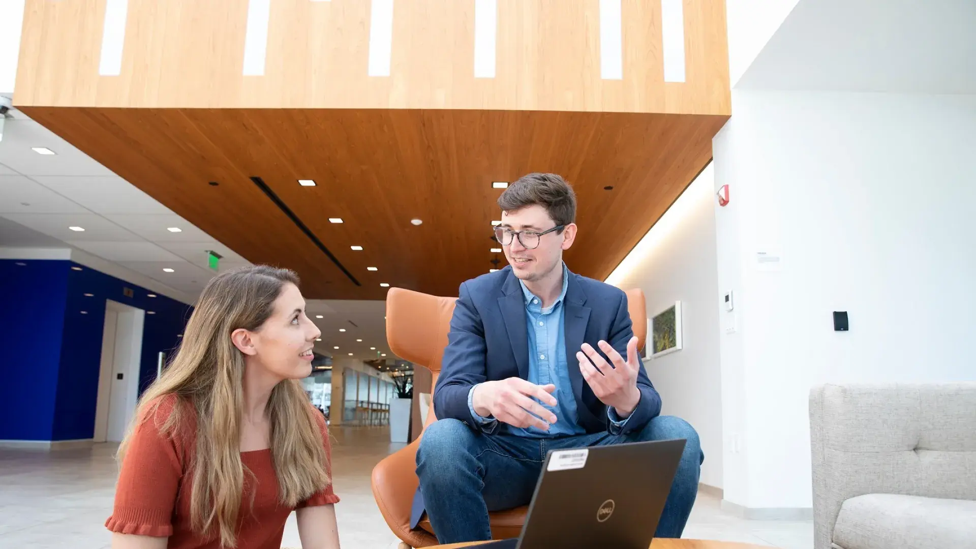 A man and a woman sitting in front of a laptop having a discussion