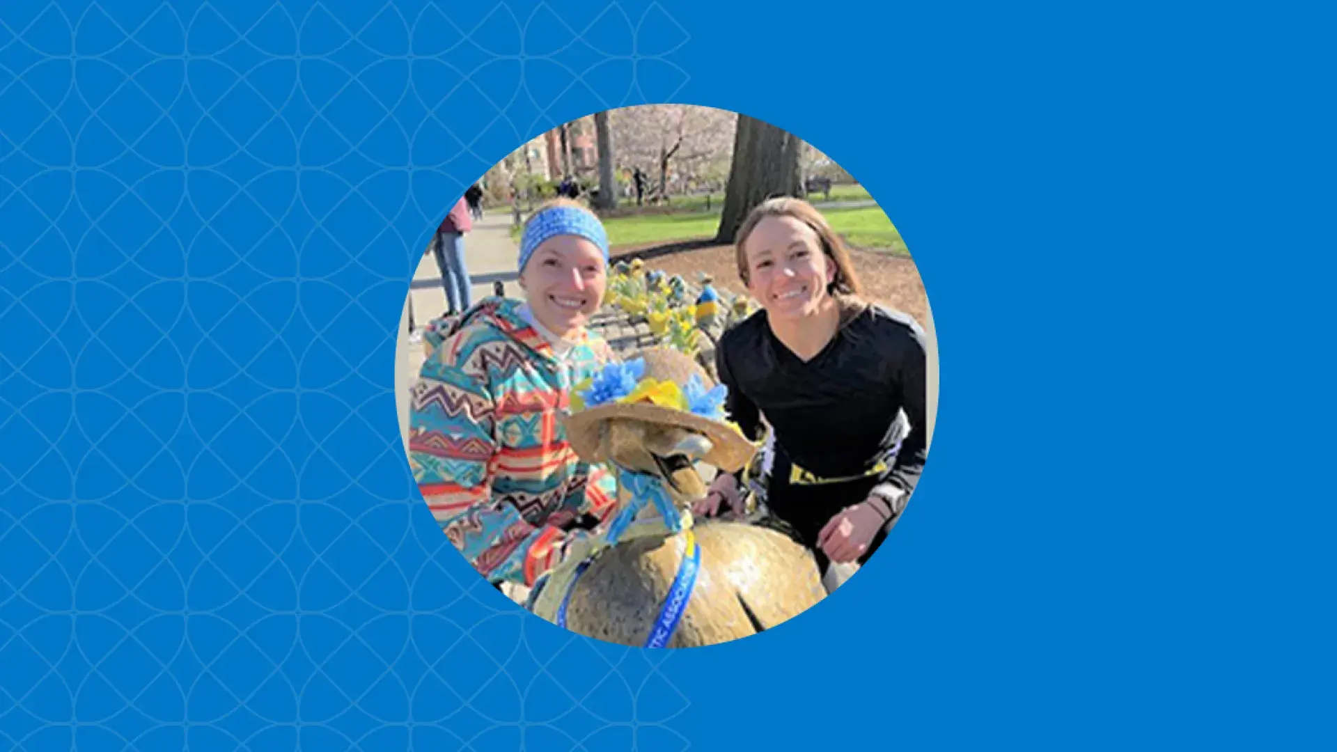 two women in running gear smile near the boston ducklings statue