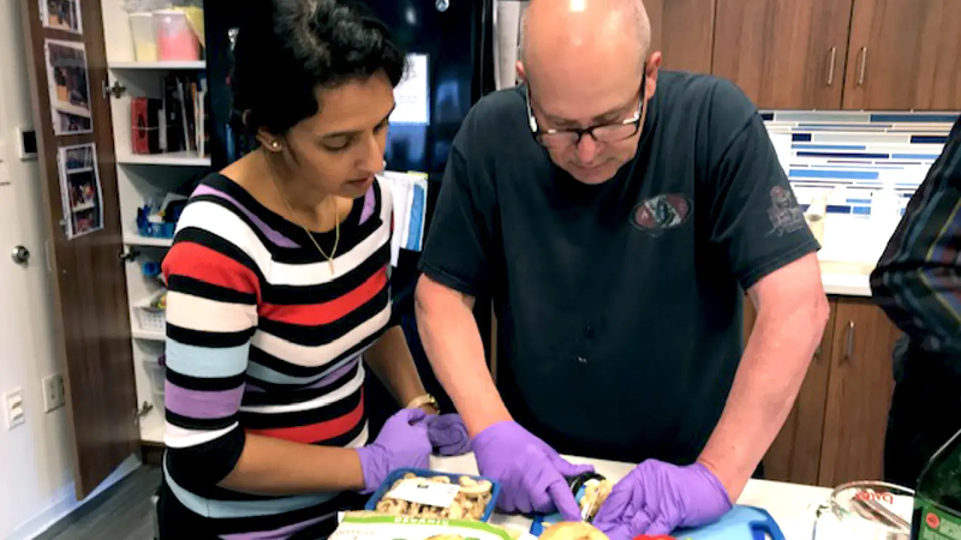 Occupational therapist guiding a patient in a cooking activity to support motor skill development and independence.