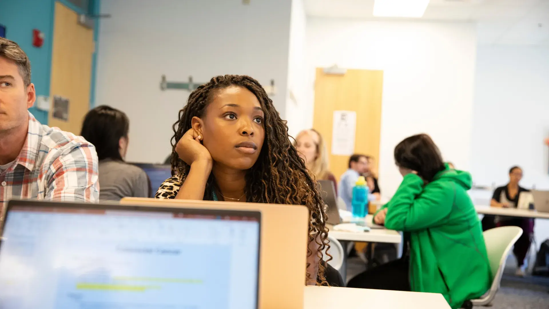 student rests head on her hand as she listens in a classroom