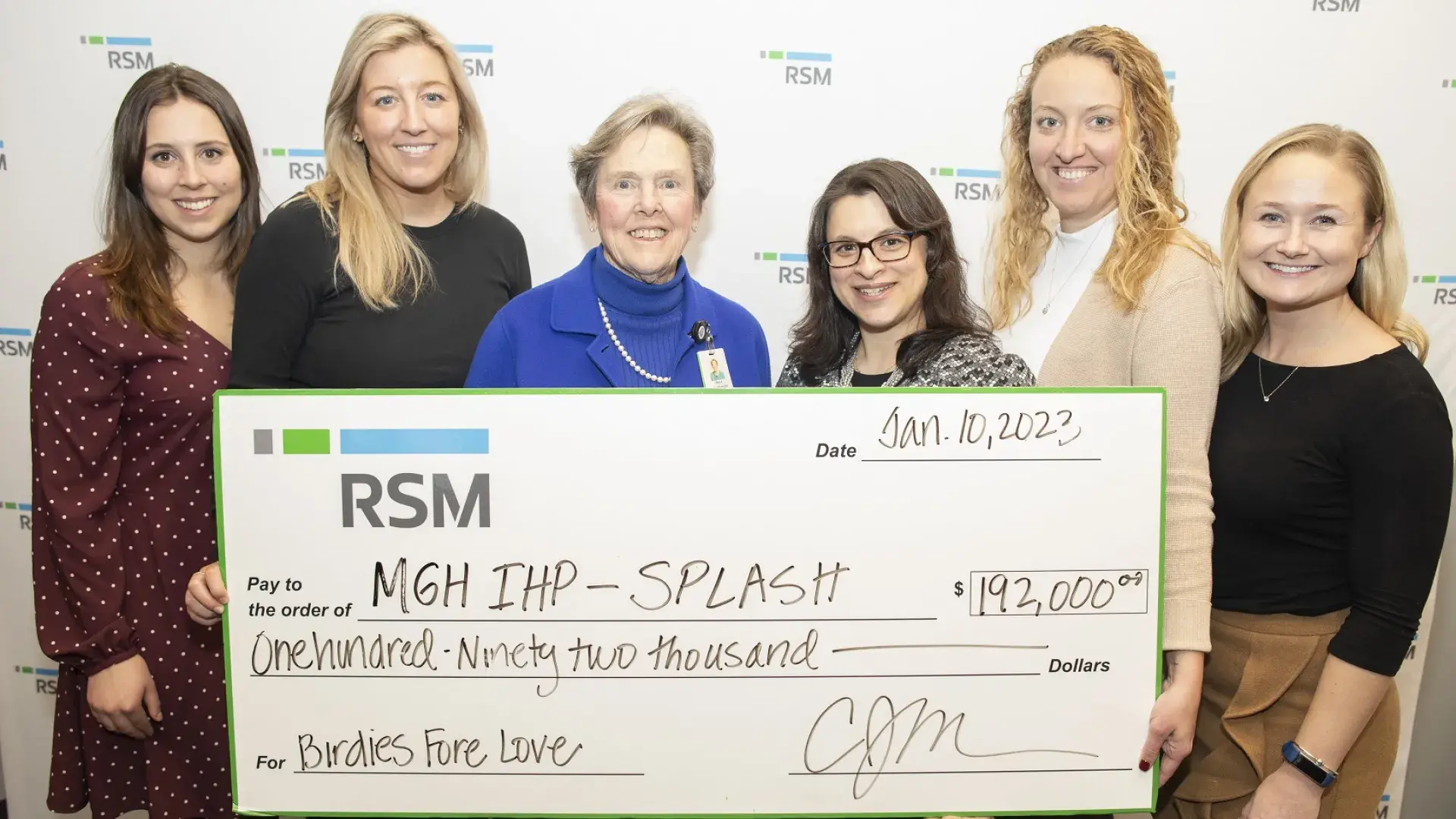 a group stands holding a check that says RSM, MGH IHP Splash $192,000