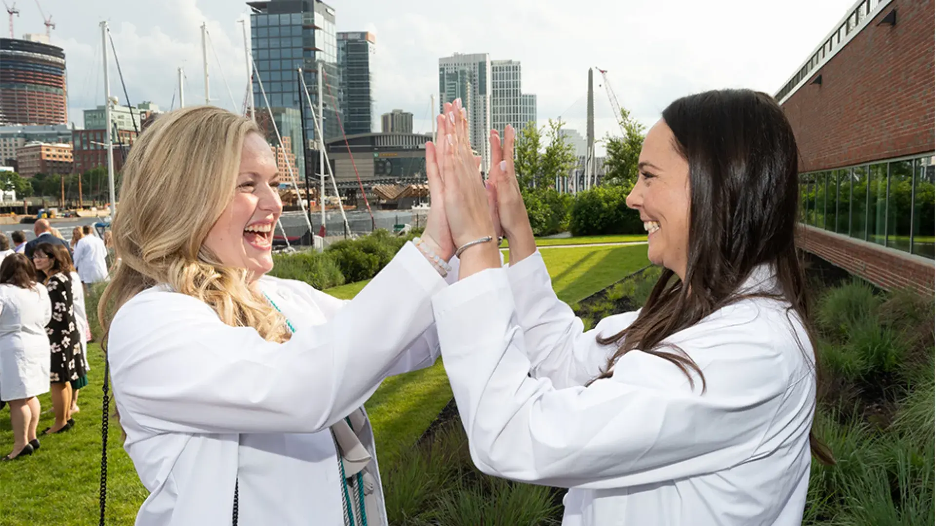 woman in white coat gives double high five to other woman in white coat
