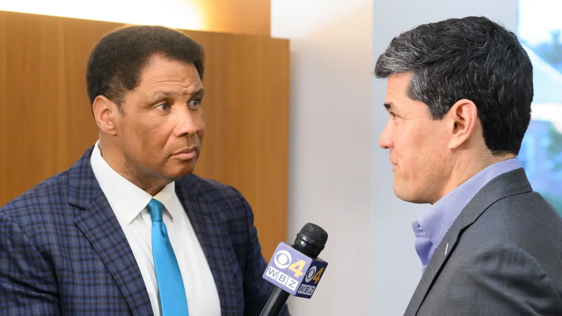 steve holds a microphone that says channel 4 on it to tedi