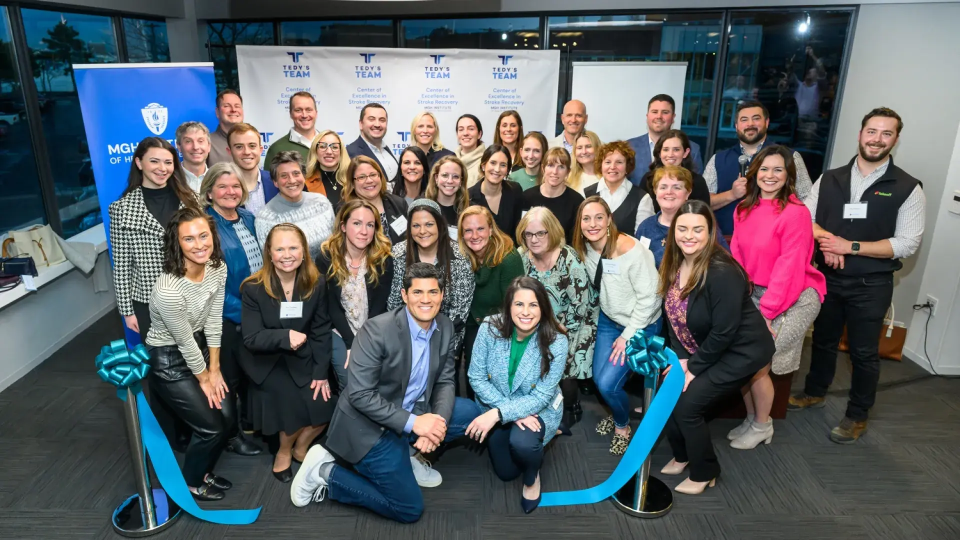 large colorful group in front of a cut ribbon